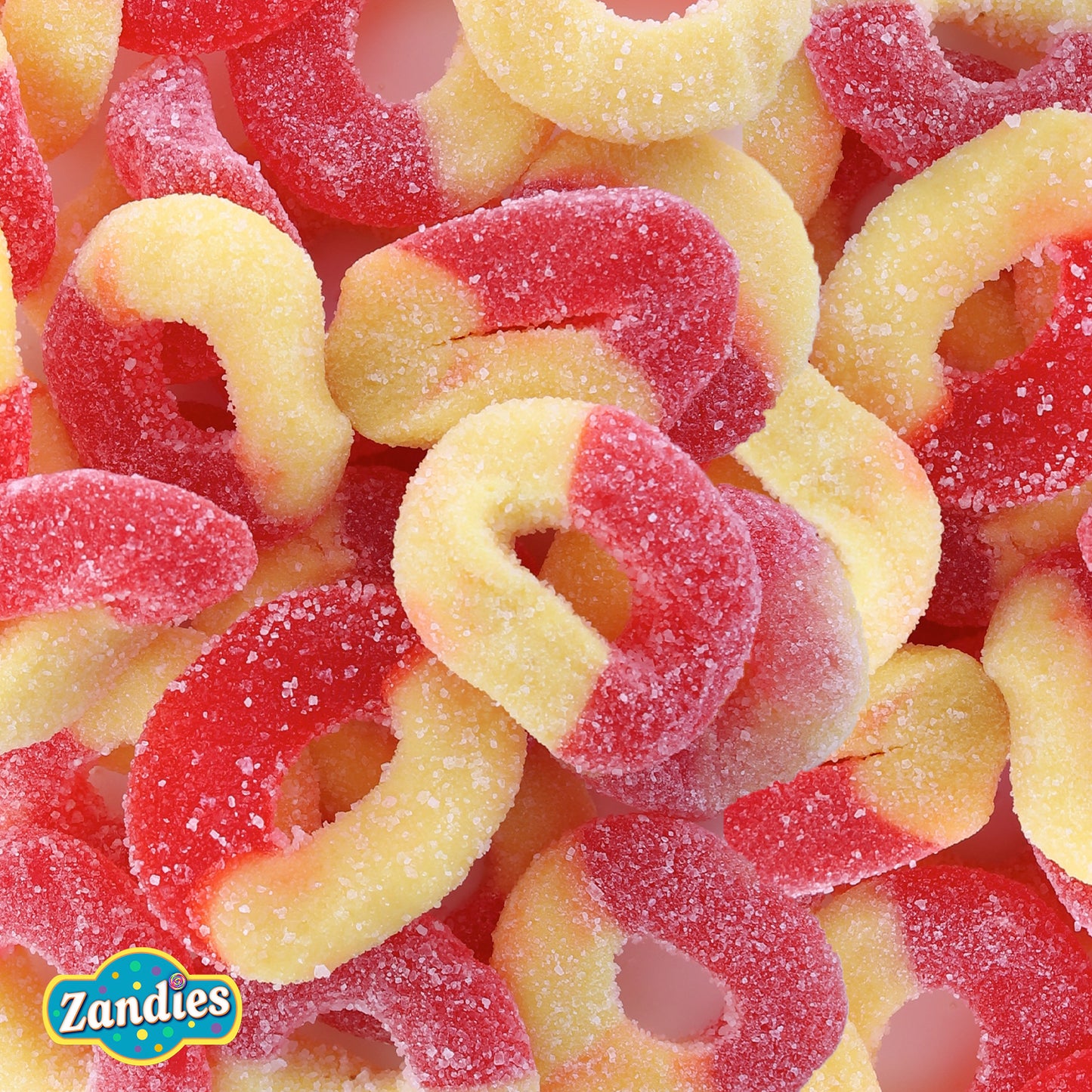 Close-up of red and yellow swirled gummi peach rings candies with Zandies logo.