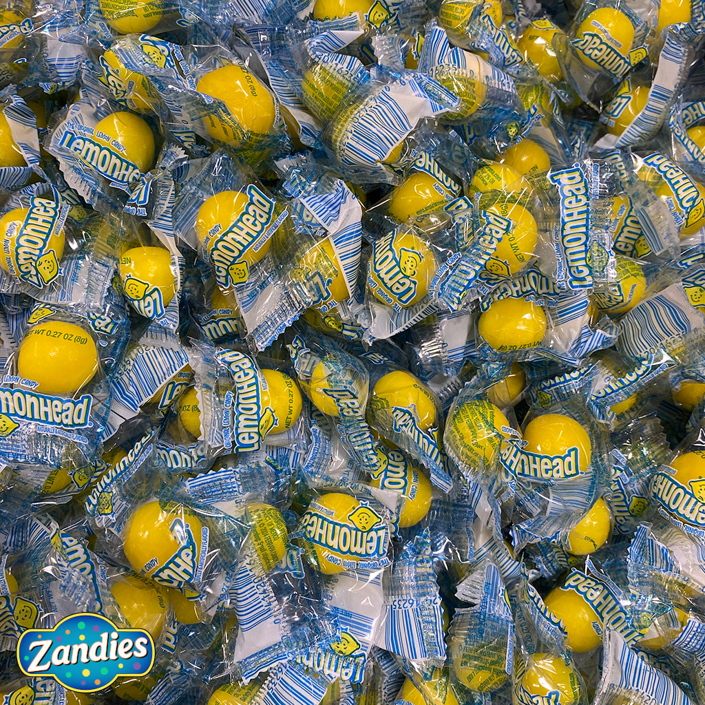 Large pile of Lemonhead candy individually wrapped. Zandies logo in the corner