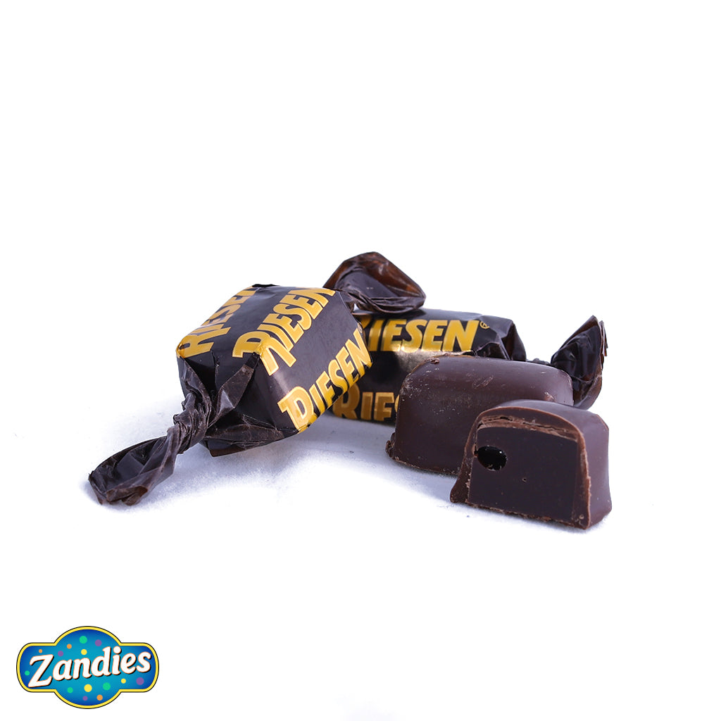 Photo of Riesen candy, in the wrapper, out of the wrapper, and cut in half to show the inside texture. Zandies logo in the corner.