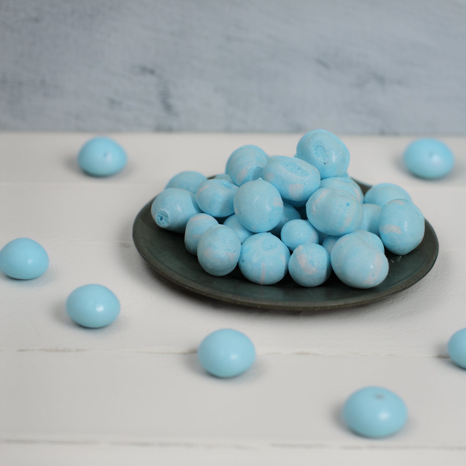 Berry Blast Candies on a plate and scattered on a white table.